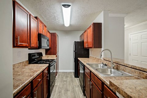 Cherry Wood Upgrade. With Cherrywood cabinets, black appliances, updated lighting